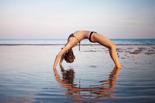 Plakát Woman wearing bikini doing yoga at