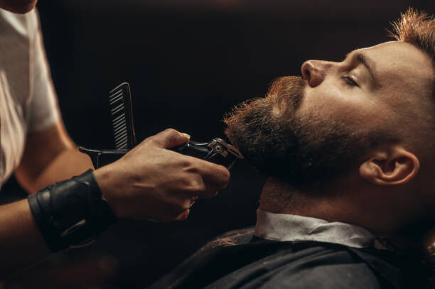 Plakát Young bearded man getting beard haircut