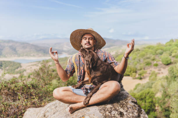 Plakát young man meditating in nature with his dog.