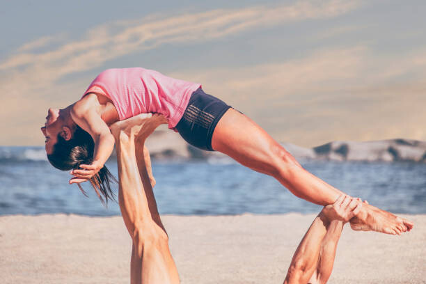 Plakát Young sporty woman practicing acroyoga exercises