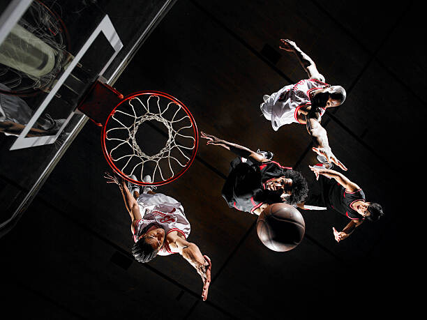 Obraz na płótnie Basketball player dunking ball over opponents,