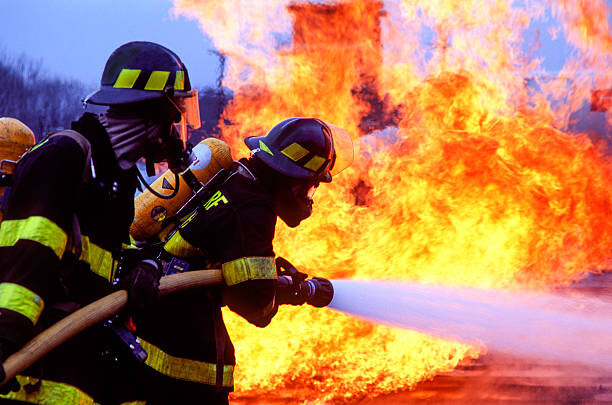 Obraz na płótnie Firemen fighting blaze with hose.