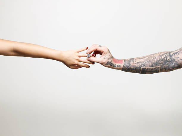 Obraz na płótnie Man with tattooed arm placing ring