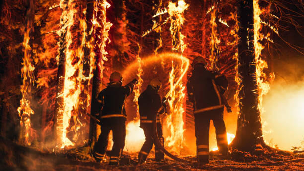 Obraz na płótnie Professional Firefighters Extinguishing Large, High-Priority Part