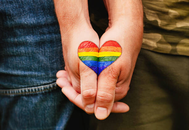 Obraz na płótnie Rainbow heart drawing on hands, LGBTQ