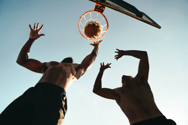 Obraz na płótnie Young athletic boys playing basketball, throwing