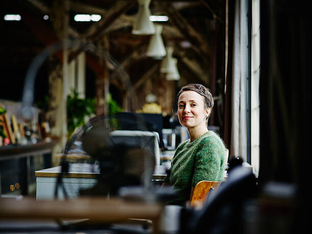 Poster Smiling businesswoman sitting at workstation