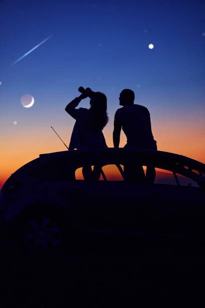 Poster Couple stargazing together with binoculars.