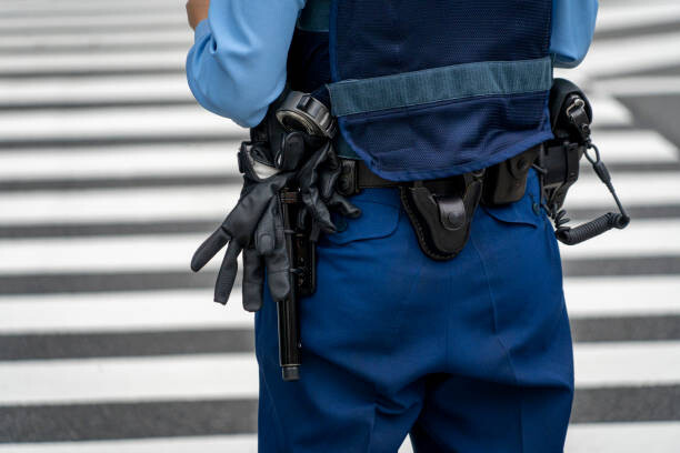 Póster Midsection Of Police Woman Standing On Road