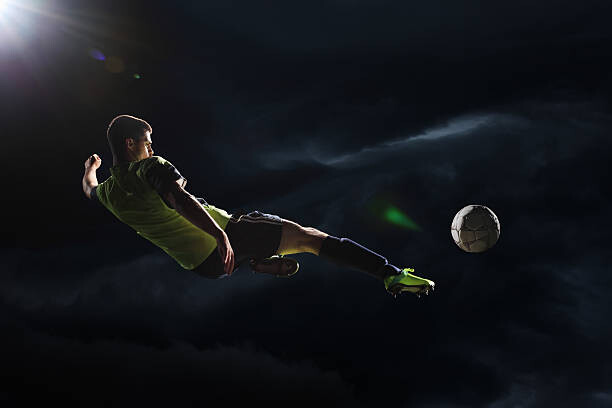 Poster Soccer player kicking the ball in the air