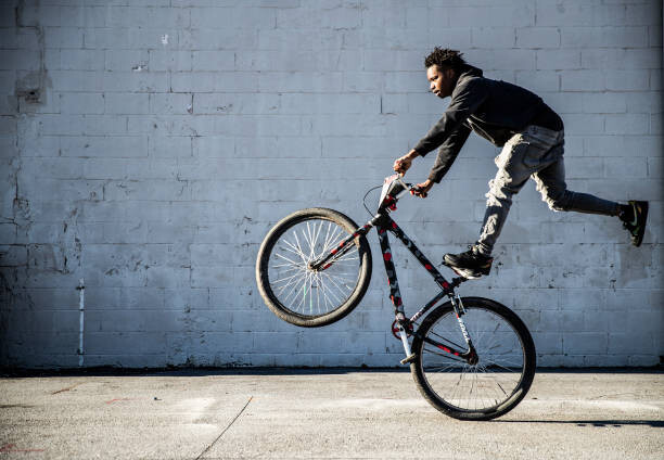 Quadro su tela Young male BMX rider performing wheelie