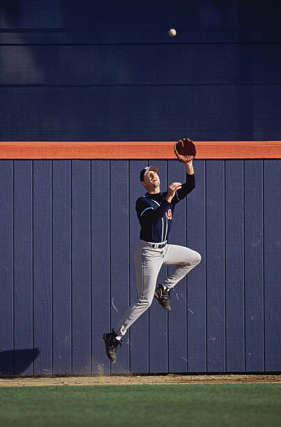 Tablou pe pânză Baseball outfielder leaping to catch ball