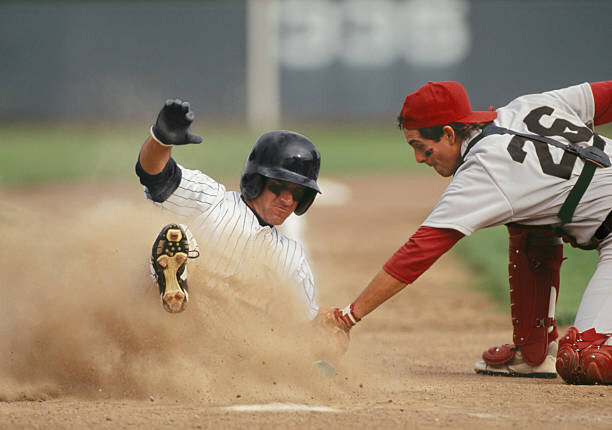 Tablou pe pânză Baseball player sliding into home plate,