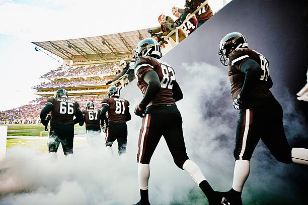 Tableau sur toile Fans cheering football team running out of tunnel