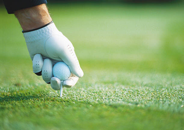 Tableau sur toile Golfer's gloved hand teeing up, close-up