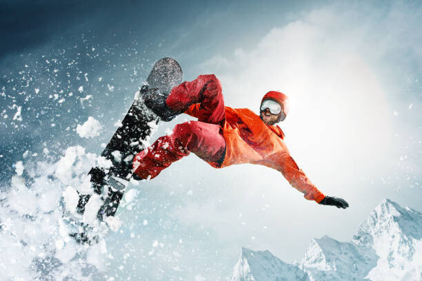 Tableau sur toile Snowboarder jumping through air with deep