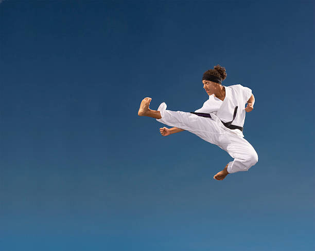 Tableau sur toile Teenage boy  kicking in mid-air,