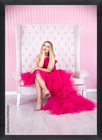 Photos blonde smiling happy woman in pink dress sitting on pink chair in pink room  in